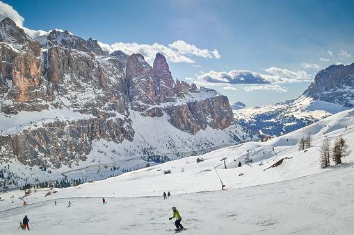 Sella towers, South Tyrol, Italy - February 12, 2020: Ski slopes and skiers at the massif called sella tower in the Italian Dolomites