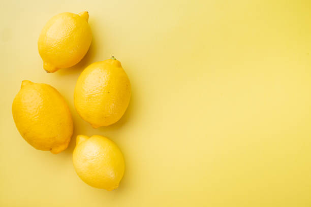 istock Lemon whole, on yellow textured summer background, with copy space for text 1458318285