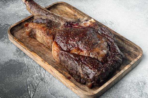 istock Grilled tomahawk beef steak, on wooden serving board, on gray stone background 1458322503