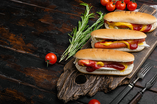 Delicious and simple hot dogs with mustard, on old dark  wooden table background, with copy space for text.