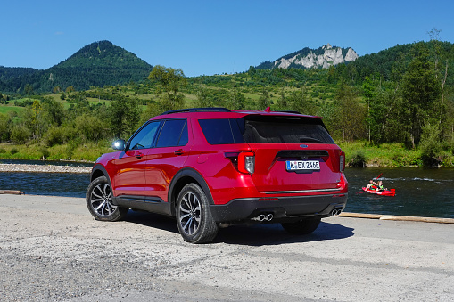 Cerveny Klastor, Slovakia - 28th August, 2020: Ford Explorer V6 Plug-in Hybrid stopped on a road in mountain scenery. The Explorer is the largest SUV from Ford in Europe.