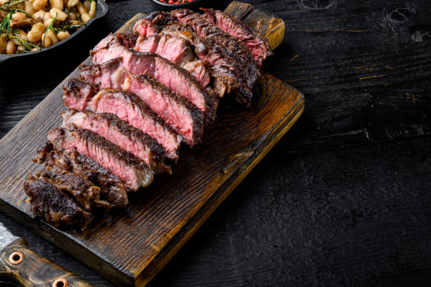 istock Sliced medium rare grilled Beef steak, rib eye cut, on wooden serving board, with copy space for text 1458330237