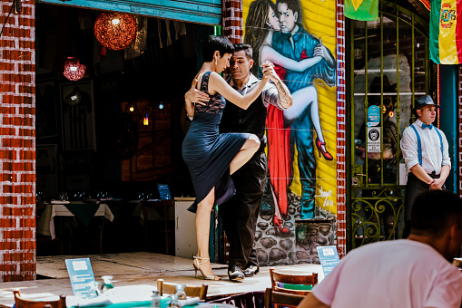 Buenos Aires, Argentina - December 21, 2022: Tango dancers performing at a restaurant stage along streets of the Caminito district in Buenos Aires Argentina