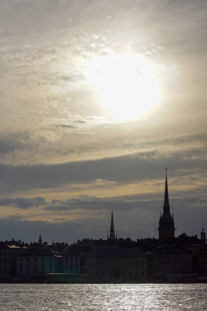 istock Silhouette of buildings against cloudy sky during sunset 1458336847