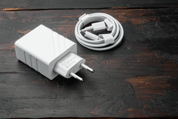 istock Usb cable with usb wall charger plug, on old dark  wooden table background, with copy space for text 1458337047