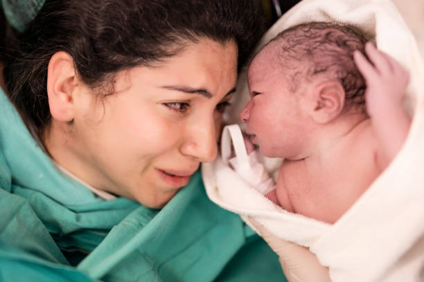 mãe e seu bebê recém-nascido na sala de cirurgia - parto - fotografias e filmes do acervo