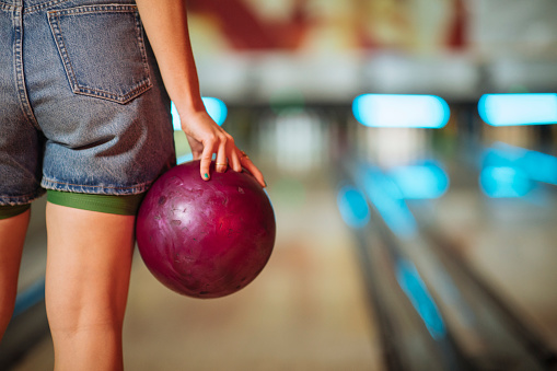 Cropped photo of woman as she holding bowling ball in her hand