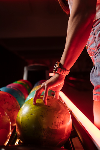 Close-up shot of a woman's hand as she picks up a bowling ball