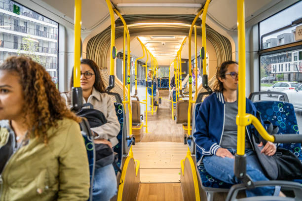 Diverse passengers riding bus and sitting at seats