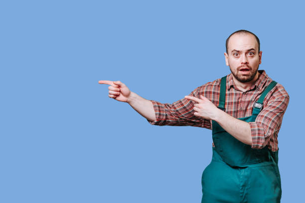 istock man is a charming and handsome farmer. He looking amazed, surprised as he points, copy space 1458350050