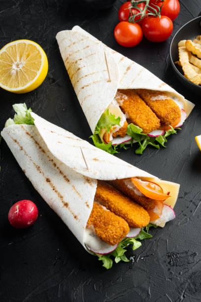 istock Fish fingers roll and tartar sauce, on black background 1458351721