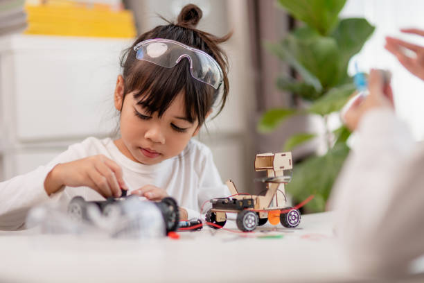 istock Asia students learn at home in coding robot cars and electronic board cables in STEM, STEAM, mathematics engineering science technology computer code in robotics for kids concept. 1458355846