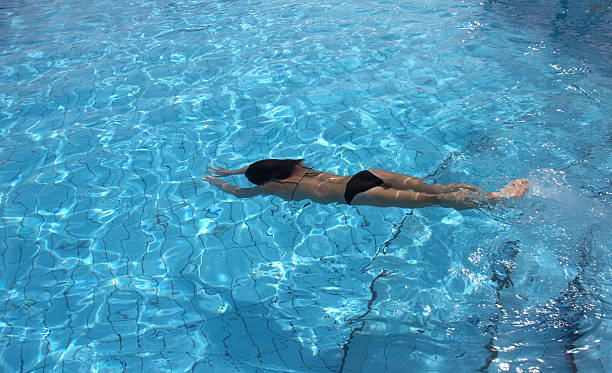 istock Woman in bikini diving into bright blue pool 145835723