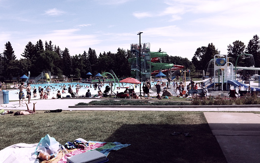 Photo adjusted to look vintage, instant film post production. People playing at an outdoor pool