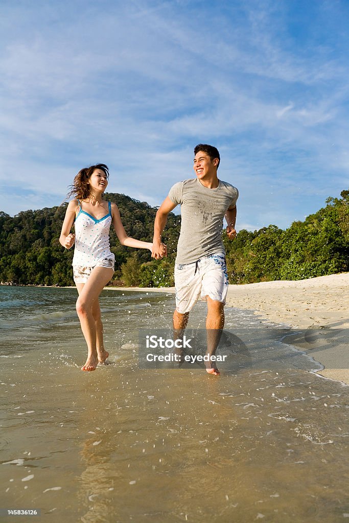 couple heureux courir le long de la plage - Photo de Adulte libre de droits