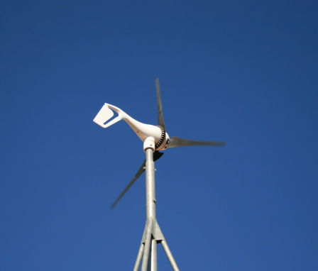 a small electric wind generator against a blue sky
