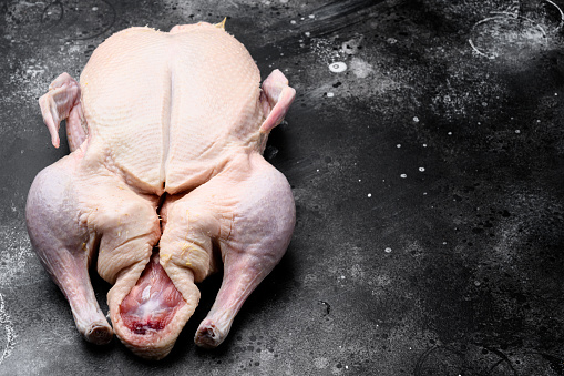 Uncooked Chicken breast fillet, raw poultry meat steaks. Black Wooden background. Top view.