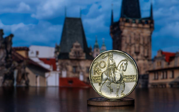 eine 20 czk-münze und andere münzen vor dem hintergrund von fragmenten von prager gebäuden, die nicht im fokus liegen - czech culture currency wealth coin stock-fotos und bilder