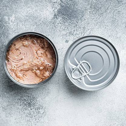 Canned Wild Yellowfin Tuna set, in tin can, on gray background, top view flat lay, square format