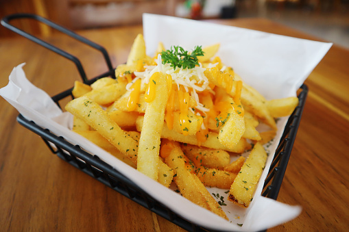 A serving of French fries topped with cheese