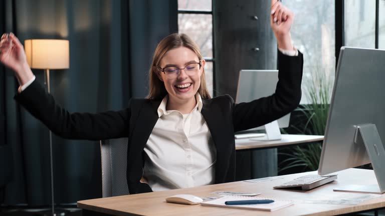 Lucky business girl user freelancer player woman sitting at table in office throws dollars up rejoicing celebrating victory win mobile game successful order offer message success payment winning.