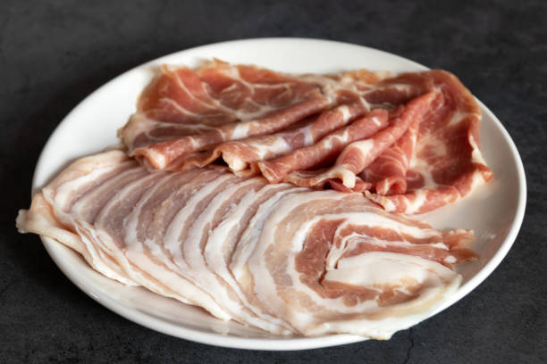 Slide raw pork with fat lines stacked on plate for shabu, BBQ or grill. stock photo