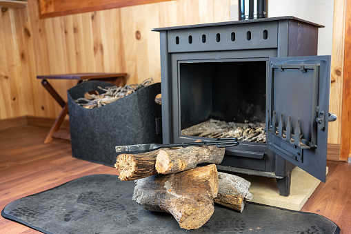 Rustic wooden stove with wood logs ready to be introduced into the fireplace