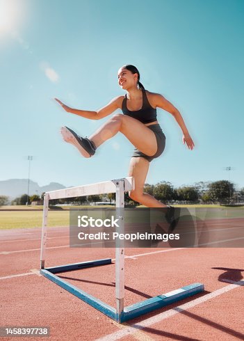 istock Fitness, hurdle and woman running in stadium track for training, health and sports workout. Exercise. cardio and endurance with strong girl runner and jump for power, performance and competition 1458397738