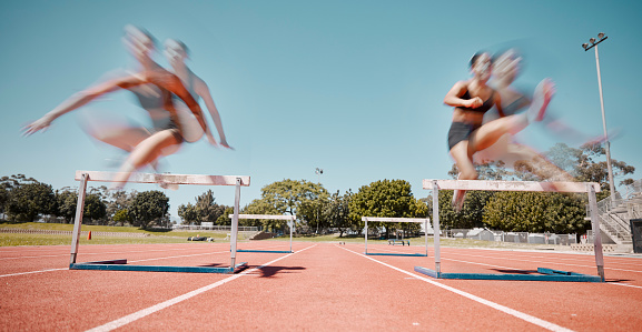 Slow shutter showing movement of young girls racing at a school track meet.