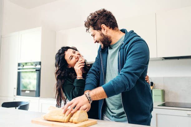 istock Young Couple Enjoying a Laugh and a Meal in a Modern Kitchen