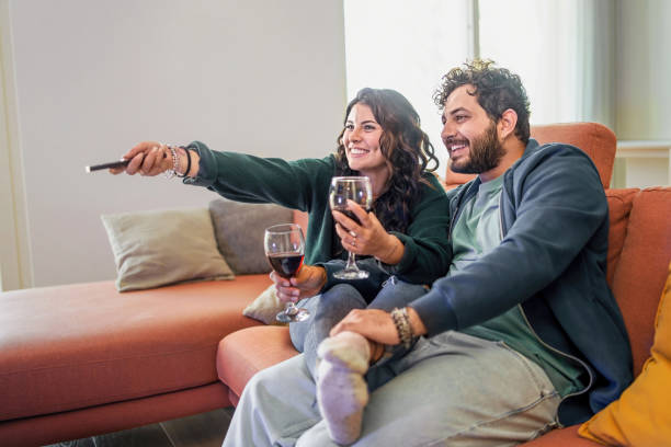 Newlyweds Relaxing at Home with Wine and Television stock photo