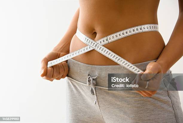 Woman Showing She Has Lost Inches Off Her Waist Stock Photo - Download Image Now - Body Mass Index, Dieting, Instrument of Measurement