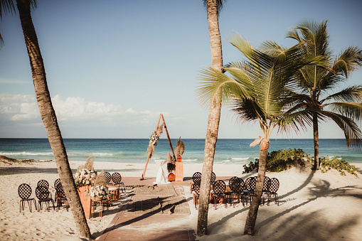 Destination wedding ceremony site on the beach with palm trees