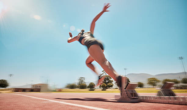 velocidad, salida en pista y mujer corriendo para el entrenamiento de la carrera de maratón, el fitness o el ejercicio para la acción de la fuerza de las piernas. compromiso de salud, destello de cielo azul y entrenamiento rápido de chicas, atletas o co - running track women running spring fotografías e imágenes de stock