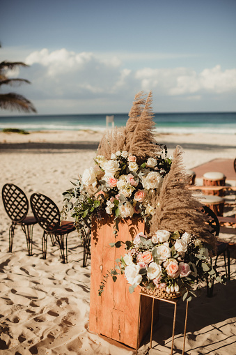Flowers and boho decor at a beach wedding on the sand
