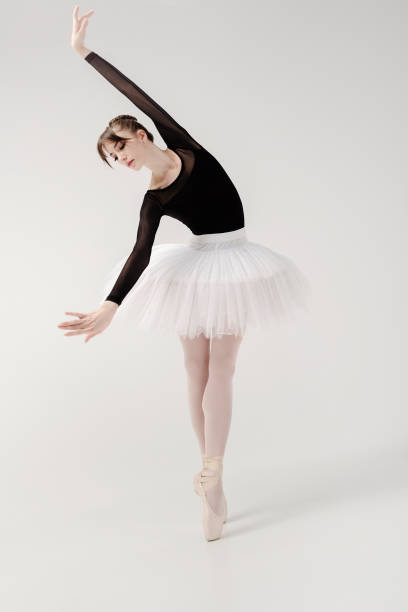 istock ballerina in a black bodysuit and tutu poses in motion showing ballet elements while standing on pointe shoes 1458403063