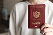 woman shows a passport, female hands, close-up, background blur