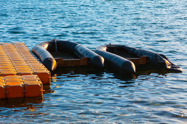 Detail of a rescue speed motorboat used for rescuing refugees/immigrants crossing the sea from Turkey in the harbor (or harbour) of the small fishing village of Agia Ermioni at the eastern coastline of the Greek Island of Chios in the Aegean Sea on a sunny midday in spring (late March). The image was captured on old-fashioned ISO 400 (grainy) 35mm black and white film by an analogue (or analog) 35 mm film camera with a red filter to darken the sky. The granularity in the image is real film grain (due to the presence of small particles of a metallic silver on the negative). Minimal post processing has been done (only adjustment of histogram). The image is part of a series of a harbour (or harbor) on the Greek Island of Chios.
