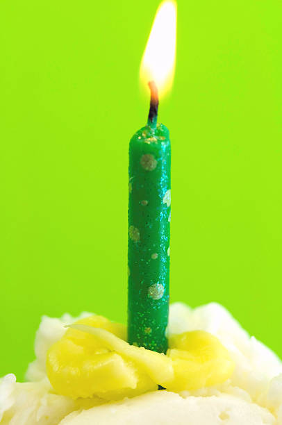 Green Candle on cake stock photo