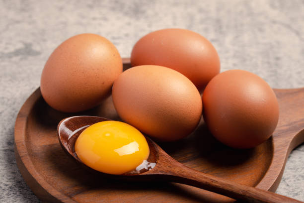 istock Fresh chicken eggs in a wooden plate 1458410097