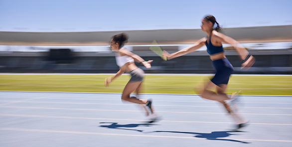 Relay race, running and sports women at a stadium for training, energy and workout. Sport, runner and baton pass on a running track by athletic team for fitness, marathon and speed performance