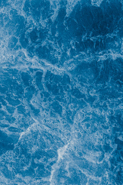 istock Dark blue sea surface with waves, splash and bubbles 1458412612