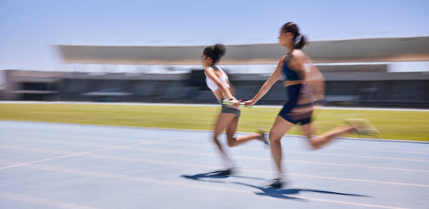 course de vitesse, relais et course féminine dans une compétition de marathon, un événement sportif ou un sprint sur piste à haute énergie. action, mouvement et travail d’équipe d’athlètes rapides, de coureurs ou de femmes cardio training pour  - marathon running motion track event photos et images de collection