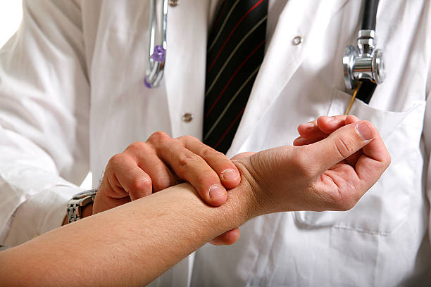 Doctor checking patient pulse on wrist stock photo