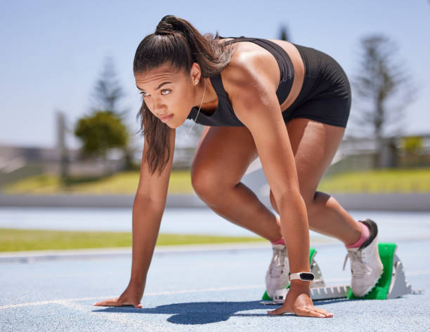 läufer, fitness und frau bereit zu laufen, rennen, sport und laufen auf der stadionbahn für sport und training. junger athlet, cardio und fokus, training für marathon oder staffel, bestimmt beim start. - starting line running sprinting alertness stock-fotos und bilder