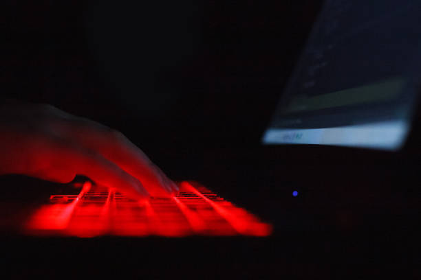 istock Person typing on laptop keyboard with red backlight 1458416793