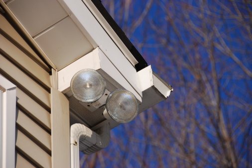 Series of 2 floodlights attached to house corner to provide security and lighting to the driveway below.