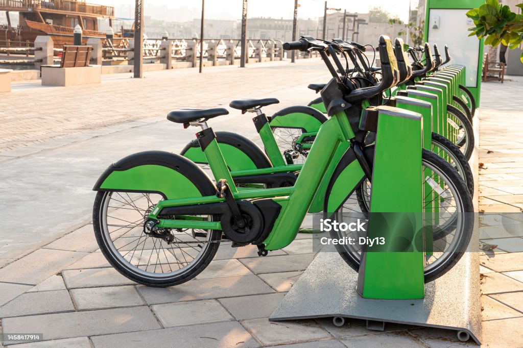 electric bicycles for rent are green in parking lot in the city center on the street. Eco-friendly mode of transport electric bicycles for rent are green in the parking lot in the city center on the street. Eco-friendly mode of transport Electric Bicycle Stock Photo