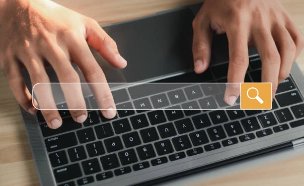 istock Businessman working on laptop with search engine browsing internet with empty search bar. Search engine optimization (SEO) concept. 1458420587