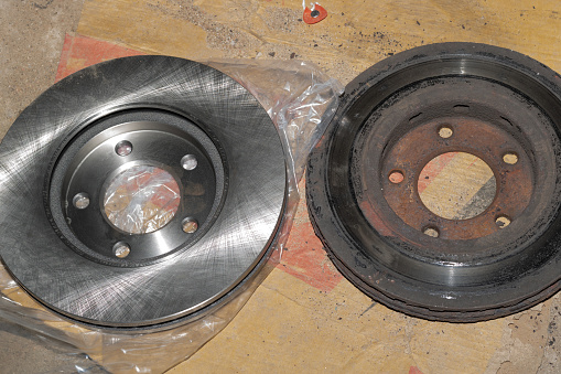 Old and new brake disc. Replacing or repairing car brakes. Brake disc wear